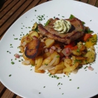 Foto zu Restaurant Campfire in der Globetrotter Lodge: BIERKUTSCHER-STEAK VOM SCHWEIN, Kräuterbutter, Bratkartoffeln und Pfannengemüse