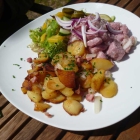 Foto zu Restaurant Campfire in der Globetrotter Lodge: HAUSGEMACHTES SAUERFLEISCH vom Schwein mit Bratkartoffeln und Gewürzgurke