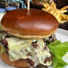 Foto zu Heimat · Küche + Bar · 25hours Hotel HafenCity: Mittagsgericht Rundstück Steak Sandwich - Rinderhüfte, Knoblauchbutter, Bergkäse und Eichblattsalat - mit Pommes und Curtice Brothers Ketchup und Mayo 20,50 €