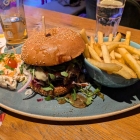 Foto zu Bratar 2: Burger mit Bergkäse, Schmorzwiebeln, BBQ-Sauce, Coleslaw und Pommes frites (Mittagstisch)