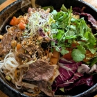 Foto zu Restaurant Maison Tom: Bun Bo Nam Bo - im Wok gebratenes Roastbeef auf warmen Reisnudeln mit Wildkräutersalat