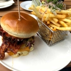 Foto zu Junkbrunnen: BACON BOMB BURGER - RIND PATTY | CHEDDAR | GEGRILLTER BACON | TOMATEN KETCHUP | MAYO | FRISCHE ZWIEBELBRUNOISE | TOMATE | LOLLO ROSSO | YELLO MUSTARD MILD